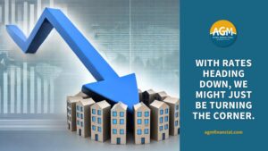 large blue arrow pointing down toward multifamily apartments suggesting interest rate cuts
